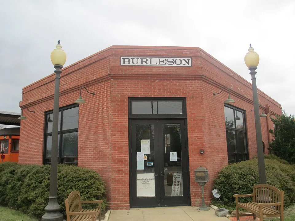 Restored red brick Burleson train station in downtown Burleson, TX with the name BURLESON above the entrance
